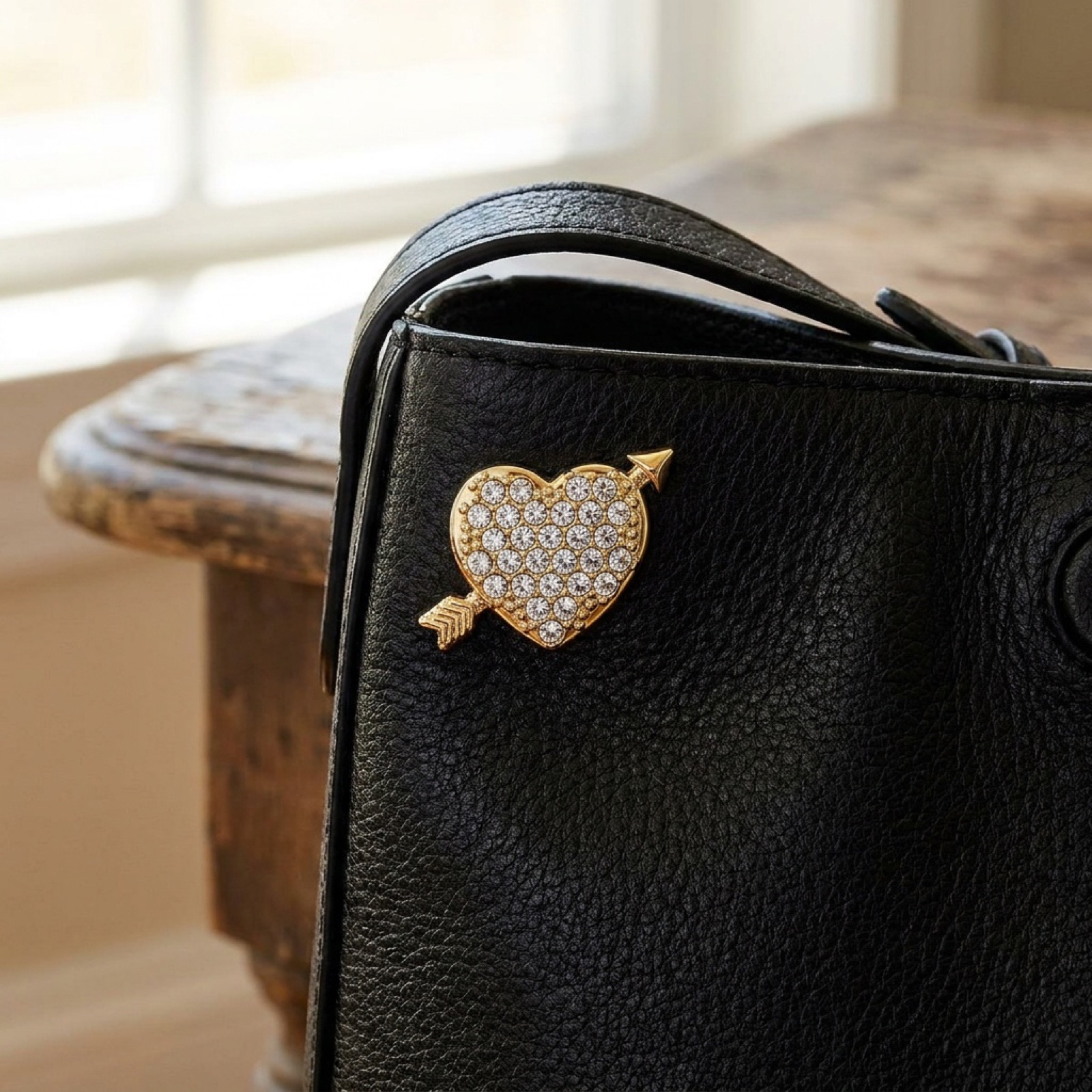 Pin's – cœur doré sur sac en cuir